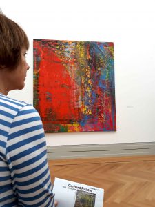 Die Künstlerin Gabriele Bobey betrachtet die abstrakte Malerei von Gerhard Richter.