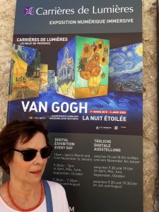 Gabriele Bobey vor dem Plakat der Ausstellung Carrières de Lumières